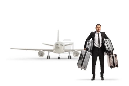 Foto de Retrato completo de un hombre de negocios sosteniendo muchas maletas frente a un avión aislado sobre fondo blanco - Imagen libre de derechos