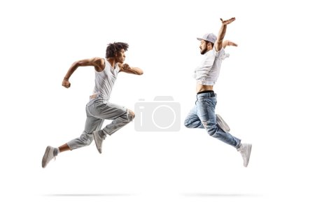 Photo for Full length profile shot of a caucasian and an african american male dancer jumping isolated on white background - Royalty Free Image