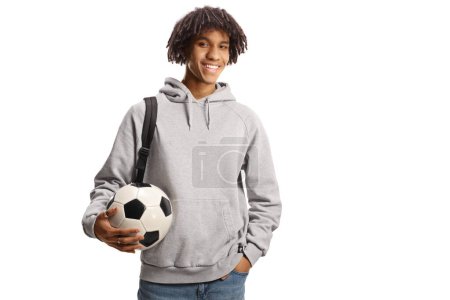 Téléchargez les photos : Étudiant afro-américain mâle avec un sac à dos tenant un ballon de football isolé sur fond blanc - en image libre de droit