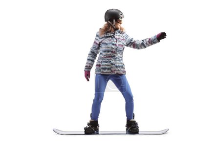 Téléchargez les photos : Plan complet d'une femelle avec lunettes et casque chevauchant un snowboard isolé sur fond blanc - en image libre de droit