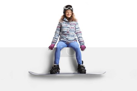 Téléchargez les photos : Jeune snowboardeuse assise sur un panneau blanc isolé sur fond blanc - en image libre de droit