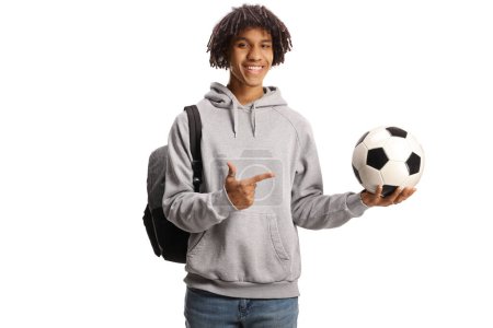 Photo for Male african american student with a backpack holding a football and pointing isolated on white background - Royalty Free Image