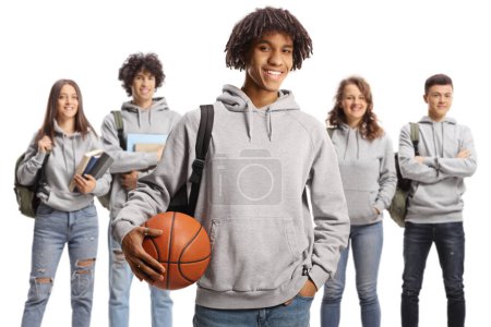 Téléchargez les photos : Male african american student holding a basketball and other students posing in the back isolated on white background - en image libre de droit