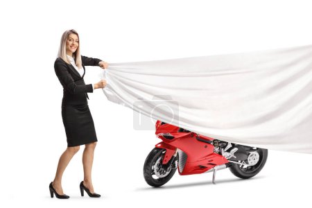 Photo for Businesswoman holing a white piece of cloth in front of a red motorbike isolated on white background - Royalty Free Image