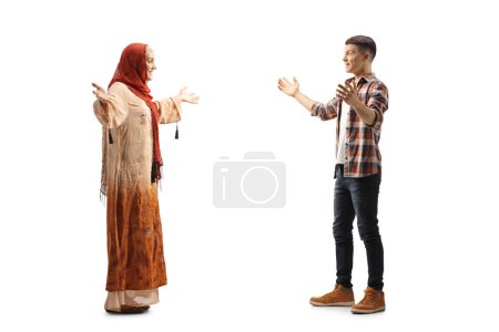 Téléchargez les photos : Profil complet d'une femme musulmane rencontrant un jeune homme décontracté isolé sur fond blanc - en image libre de droit