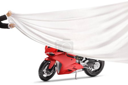 Téléchargez les photos : Mains masculines tenant un morceau de tissu blanc devant une moto rouge isolée sur fond blanc - en image libre de droit