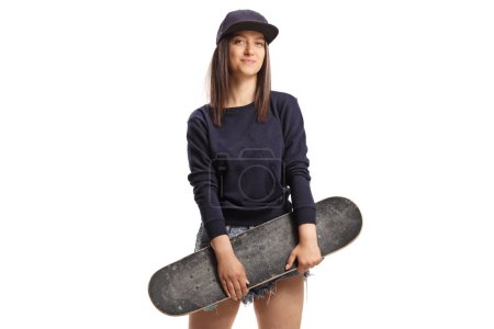 Téléchargez les photos : Jeune patineuse tenant un skateboard isolé sur fond blanc - en image libre de droit