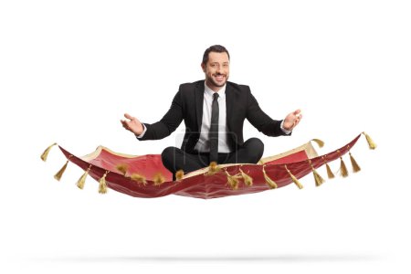 Foto de Empresario sentado en una alfombra y volando aislado sobre fondo blanco - Imagen libre de derechos
