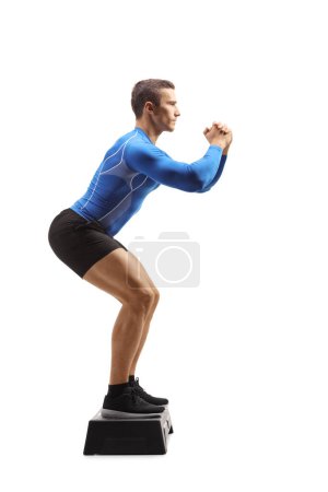 Photo for Full length portrait of a male step aerobic instructor showing an exercise isolated on white background - Royalty Free Image