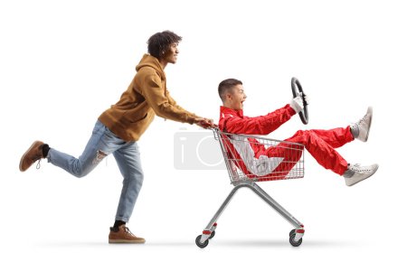 Photo for African american guy running and pushing a car racer inside a shopping cart isolated on white background - Royalty Free Image