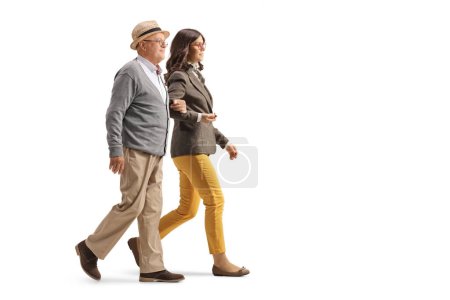 Téléchargez les photos : Elderly man holding a young woman under arm and walking together isolated on white background - en image libre de droit