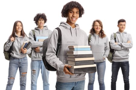 Photo for African american male student holding a pile of books and a group of caucasian students posing behind isolated on white background - Royalty Free Image