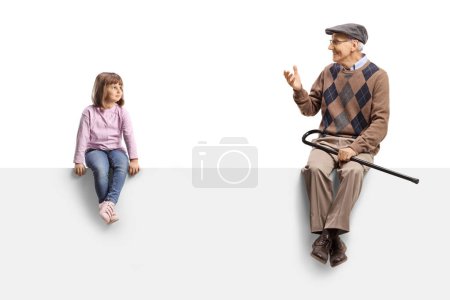 Téléchargez les photos : Girl sitting on a blank panel and listening to grandfather isolated on white background - en image libre de droit