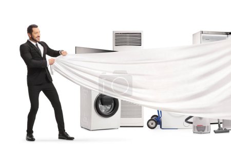 Foto de Businessman holding a white piece of cloth in front of electrical appliances isolated on white background - Imagen libre de derechos