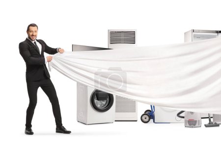 Foto de Sales manager holding a white piece of cloth in front of electrical appliances isolated on white background - Imagen libre de derechos