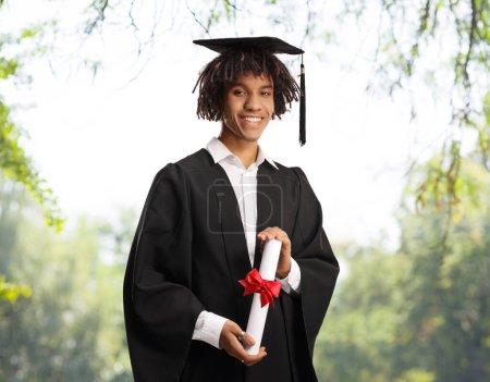 Photo for Male african american graduate student holding a diploma outdoors - Royalty Free Image