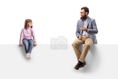 Téléchargez les photos : Man talking to a little girl seated on a blank white panel isolated on white background - en image libre de droit