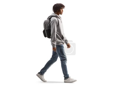 Téléchargez les photos : Full length profile shot of an african american male student walking isolated on white background - en image libre de droit