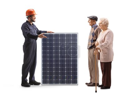 Foto de Trabajador de fábrica con un panel solar hablando con una pareja de ancianos aislados sobre fondo blanco - Imagen libre de derechos