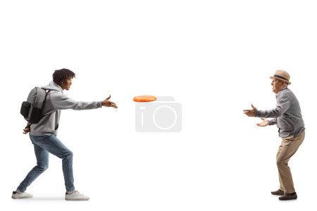 Photo for Full length profile shot of a young african american man playing a flying disc to an elderly man isolated on white background - Royalty Free Image