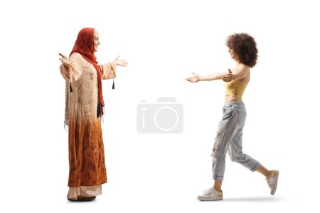 Foto de Young muslim woman meeting a caucasian young woman isolated on white background - Imagen libre de derechos