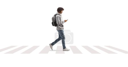 Photo for Full length profile shot of a young african american man using a phone and crossing street isolated on white background - Royalty Free Image