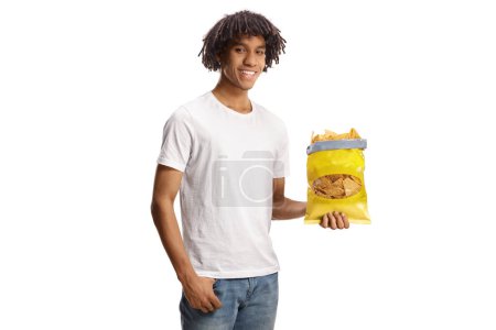 Foto de Young african american man holding a pack of tortilla chips isolated on white background - Imagen libre de derechos