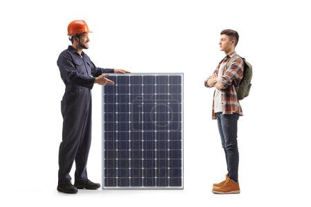 Foto de Trabajador de la fábrica explicando sobre un panel solar a un estudiante masculino aislado sobre fondo blanco - Imagen libre de derechos
