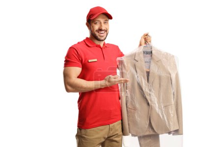 Foto de Trabajador masculino mostrando un traje de tintorería aislado en un fondo blanco - Imagen libre de derechos