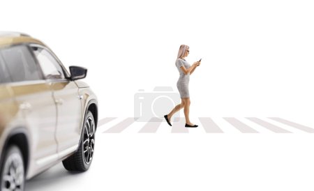 Photo for Car driving towards a pedestrian crossing and woman walking and using a smartphone isolated on white background - Royalty Free Image