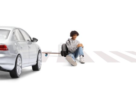 Photo for Car at a pedestrian crossing and an african american guy with a skateboard sitting with an injured leg isolated on white background - Royalty Free Image