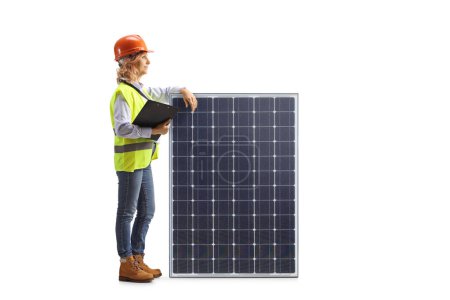 Photo for Female engineer leaning on a solar panel isolated on white background - Royalty Free Image
