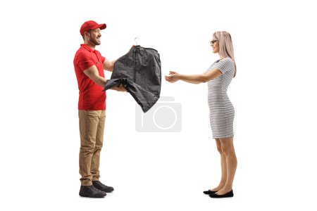 Foto de Hombre entregando ropa en una percha con una cubierta a una mujer aislada en un fondo blanco - Imagen libre de derechos