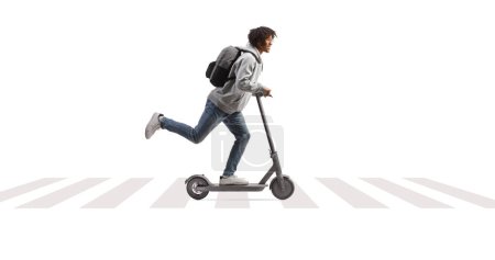 Photo for Full length profile shot of an african american male student riding an electirc scooter on e pedestrian crossing isolated on white background - Royalty Free Image