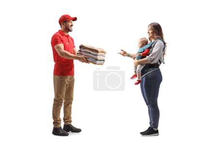 Foto de Hombre entregando una pila de ropa doblada a una madre con una ropa de bebé aislada sobre un fondo blanco - Imagen libre de derechos