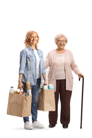 Photo for Elderly mother and daughter posing with grocery bags isolated on white background - Royalty Free Image
