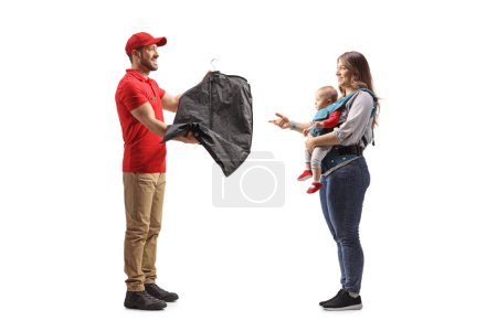 Foto de Hombre entregando ropa de tintorería a una madre con un bebé aislado sobre un fondo blanco - Imagen libre de derechos