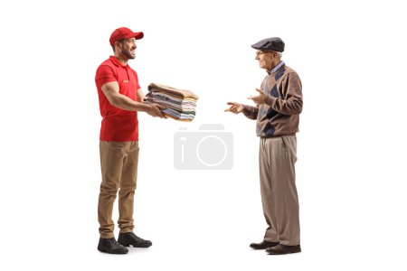 Foto de Hombre entregando ropa de limpieza en seco a un anciano aislado sobre un fondo blanco - Imagen libre de derechos