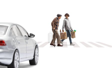 Photo for Car driving towards a young african american man and a senior with grocery bags at a pedestrian crossing isolated on white background - Royalty Free Image