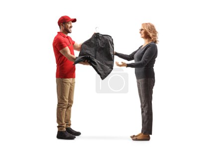 Téléchargez les photos : Homme livrant des vêtements de nettoyage à sec à une femme isolée sur un fond blanc - en image libre de droit