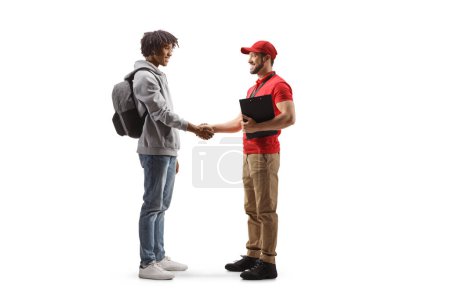 Photo for Full length profile shot of an african american young man  shaking hands with a delivery guy isolated on white background - Royalty Free Image