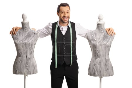Photo for Young tailor with a measuring tape smiling and leaning on a mannequin torso isolated on white background - Royalty Free Image