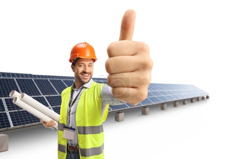 Photo for Cheerful male engineer with blueprints gesturing thumbs up at a photvoltaic farm isolated on white background - Royalty Free Image