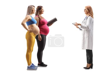 Téléchargez les photos : Plan complet du profil de deux femmes enceintes parlant à une femme médecin isolée sur fond blanc - en image libre de droit