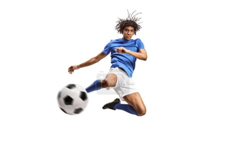 Téléchargez les photos : Un footballeur afro-américain sautant et frappant un ballon isolé sur fond blanc - en image libre de droit