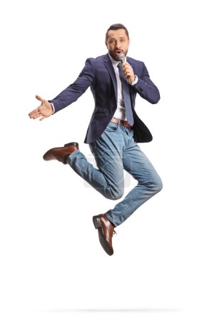 Téléchargez les photos : Homme excité avec un micro sautant et chantant isolé sur fond blanc - en image libre de droit