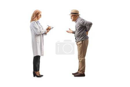 Photo for Full length profile shot of an elderly man holding his painful back and talking to a female doctor isolated on white background - Royalty Free Image