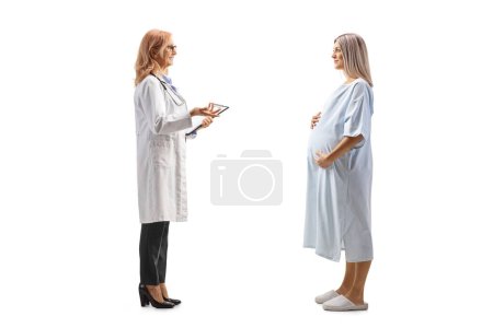 Foto de Inyección de perfil completo de una doctora que habla con una mujer embarazada hospitalizada aislada sobre fondo blanco - Imagen libre de derechos