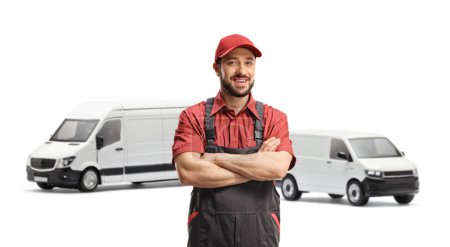 Photo for Male worker in a uniform posing with crossed arms with two white vans in the back isolated on white background - Royalty Free Image