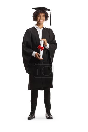 Photo for Full length portrait of a happy male african american student wearing a graduation gown and holding a diploma isolated on white background - Royalty Free Image
